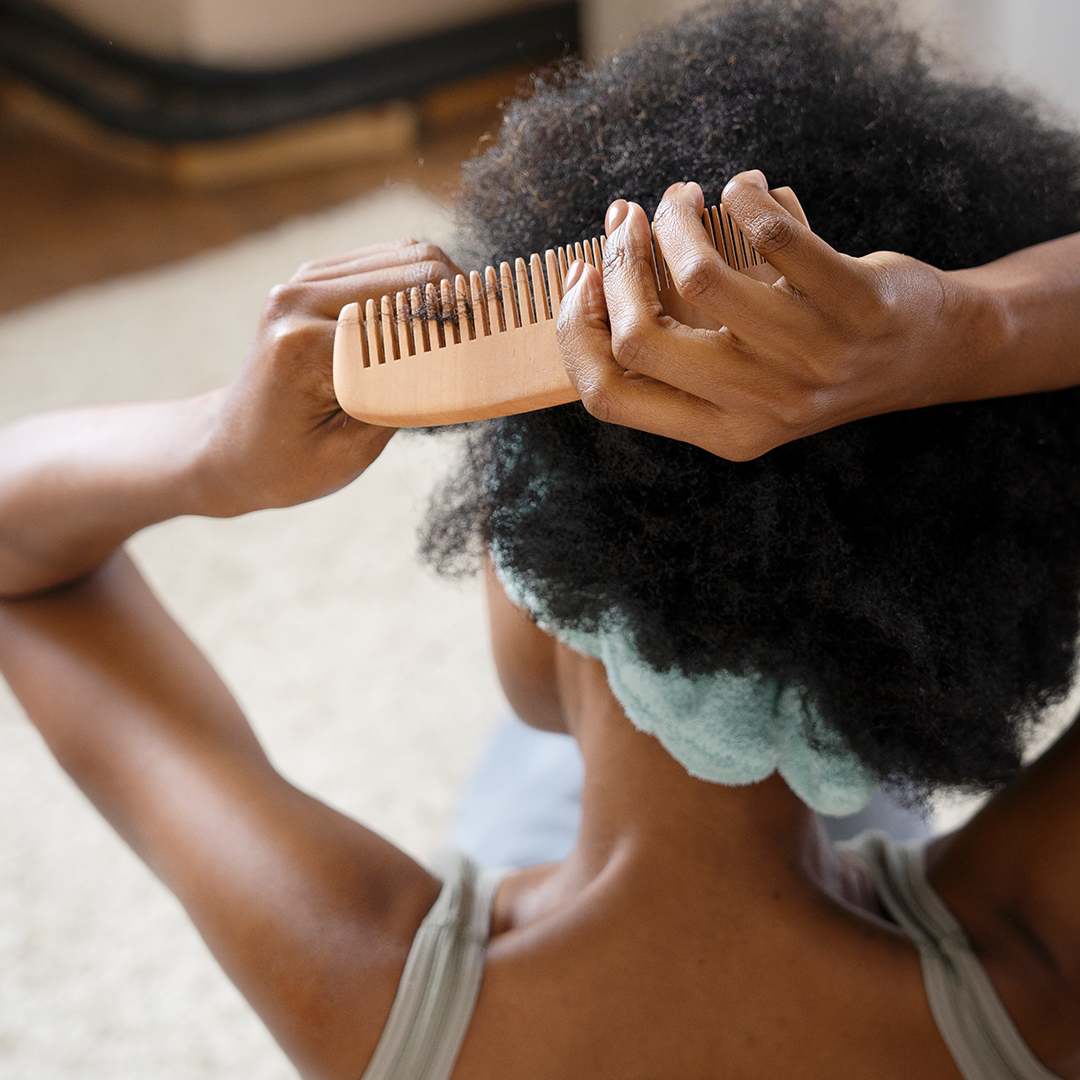 Afro hair black girl combing hair